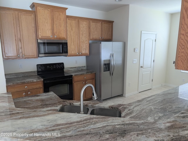 109 Fairmont Dr, Spring Hill, FL 34609 - kitchen with appliances with stainless steel finishes, brown cabinets, and dark stone countertops