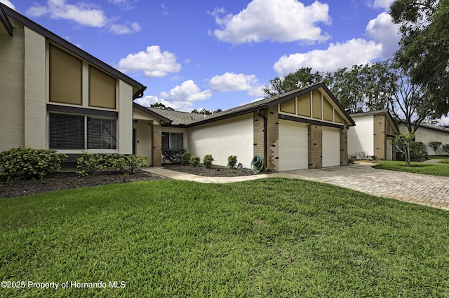 7385 Crestwood Dr, Weeki Wachee, FL 34613 - mid-century modern home featuring brick siding, a front yard, an attached garage, and driveway