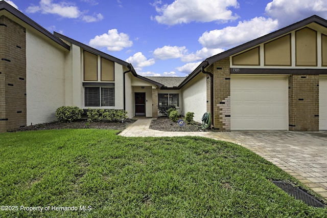 7385 Crestwood Dr, Weeki Wachee, FL 34613 - view of front of property featuring brick siding, decorative driveway, a front lawn, and stucco siding