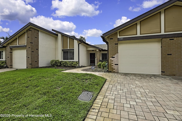 7385 Crestwood Dr, Weeki Wachee, FL 34613 - mid-century inspired home with brick siding, a garage, and decorative driveway