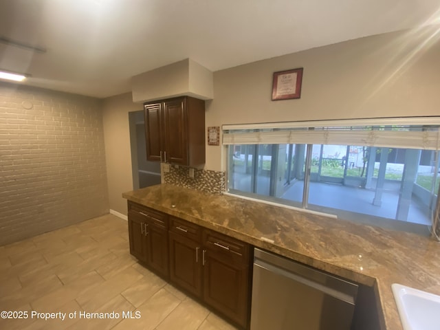 1392 Piper Rd, Spring Hill, FL 34606 - kitchen with dishwasher, brick wall, dark stone counters, dark brown cabinetry, and backsplash