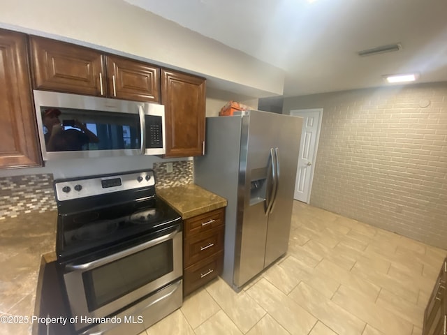 1392 Piper Rd, Spring Hill, FL 34606 - kitchen featuring stainless steel appliances, brick wall, and light tile patterned flooring