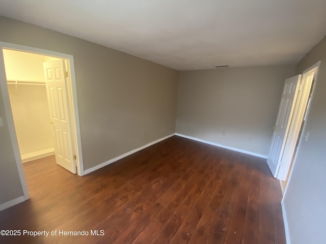 1392 Piper Rd, Spring Hill, FL 34606 - unfurnished bedroom with dark wood finished floors, a spacious closet, and a closet