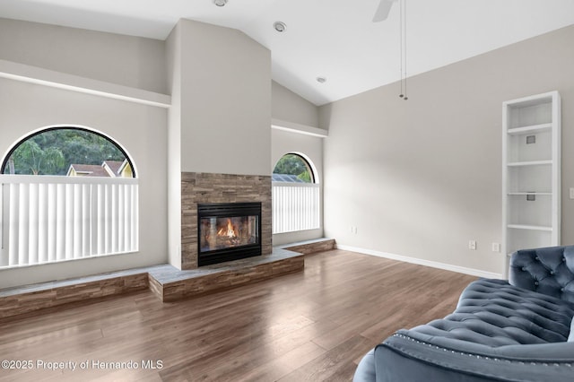 13125 Jessica Dr, Spring Hill, FL 34609 - living room with wood finished floors, a glass covered fireplace, high vaulted ceiling, and a ceiling fan