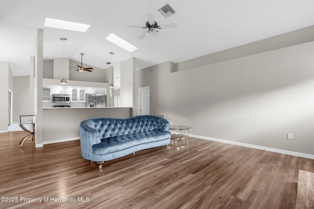 13125 Jessica Dr, Spring Hill, FL 34609 - sitting room featuring a ceiling fan, a skylight, wood finished floors, and high vaulted ceiling