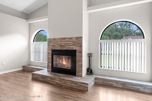 13125 Jessica Dr, Spring Hill, FL 34609 - unfurnished living room with high vaulted ceiling, wood finished floors, and a tile fireplace