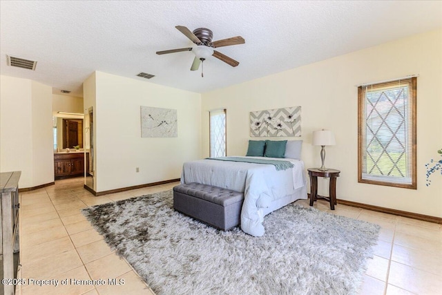 4276 River Birch Dr, Spring Hill, FL 34607 - bedroom with light tile patterned floors, a textured ceiling, a ceiling fan, and connected bathroom