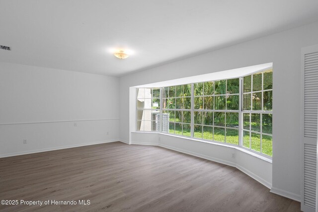 8410 Lakehill Ct, Spring Hill, FL 34608 - empty room featuring healthy amount of natural light and wood finished floors