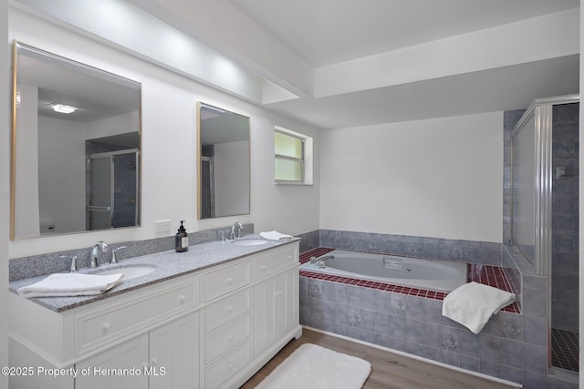 8410 Lakehill Ct, Spring Hill, FL 34608 - bathroom featuring wood finished floors, double vanity, a bath, and a shower stall