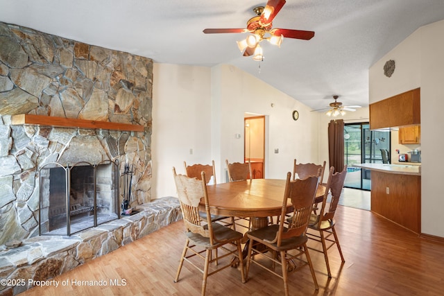 13345 Convent Garden Rd, Brooksville, FL 34613 - dining area featuring lofted ceiling, a ceiling fan, wood finished floors, and a fireplace