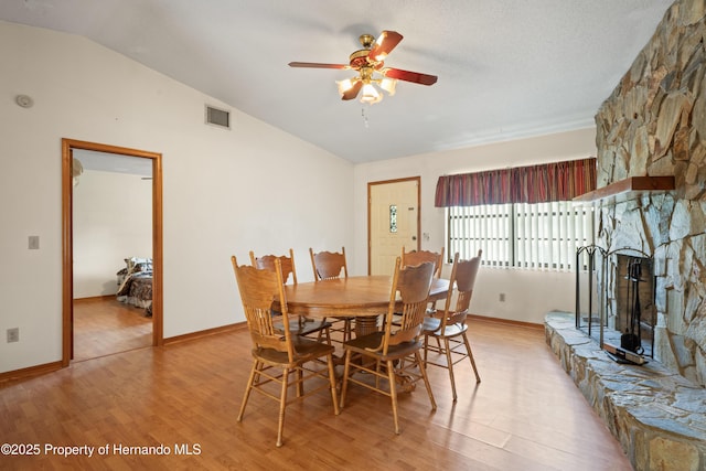 13345 Convent Garden Rd, Brooksville, FL 34613 - dining area with ceiling fan, light wood-style floors, lofted ceiling, and a stone fireplace
