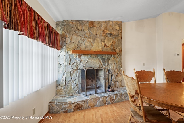 13345 Convent Garden Rd, Brooksville, FL 34613 - dining space with wood finished floors, a stone fireplace, and vaulted ceiling