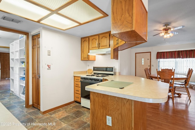 13345 Convent Garden Rd, Brooksville, FL 34613 - kitchen with white range with gas cooktop, under cabinet range hood, a peninsula, light countertops, and a ceiling fan