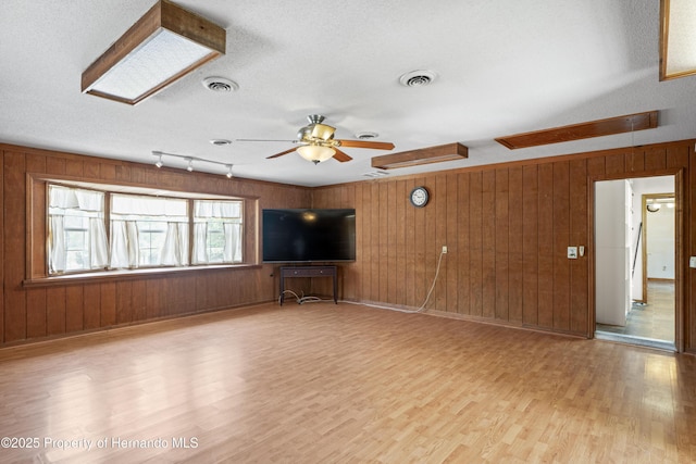 13345 Convent Garden Rd, Brooksville, FL 34613 - unfurnished living room with wood finished floors, a ceiling fan, wood walls, and a textured ceiling
