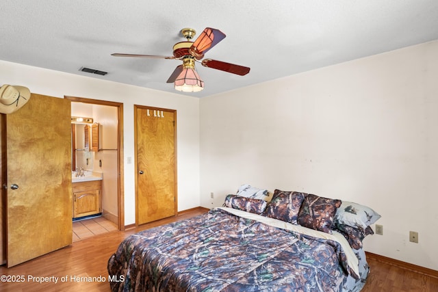 13345 Convent Garden Rd, Brooksville, FL 34613 - bedroom with light wood-style flooring, a ceiling fan, and connected bathroom