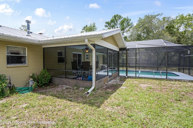 13345 Convent Garden Rd, Brooksville, FL 34613 - back of property featuring a lawn, an outdoor pool, a metal roof, and glass enclosure
