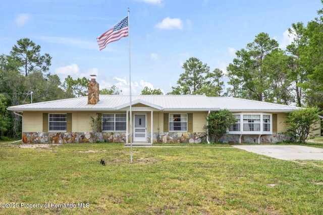 13345 Convent Garden Rd, Brooksville, FL 34613 - ranch-style house featuring stone siding, a chimney, a front yard, and a metal roof