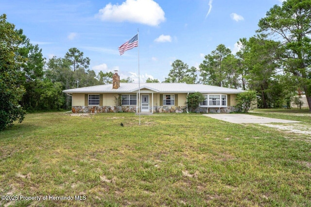 13345 Convent Garden Rd, Brooksville, FL 34613 - ranch-style house featuring a chimney, stone siding, a front yard, and a metal roof