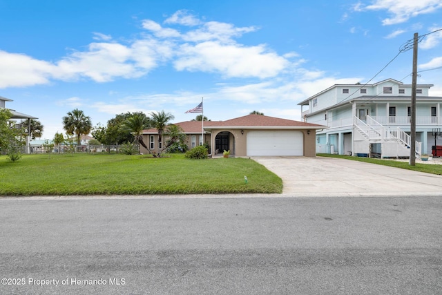 4299 Bellaire Dr, Hernando Beach, FL 34607 - view of front of home featuring an attached garage, driveway, a front lawn, and stucco siding