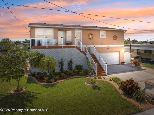 13027 Beacon Ct, Hudson, FL 34667 - view of front facade with stucco siding, an attached garage, driveway, a front lawn, and stairs