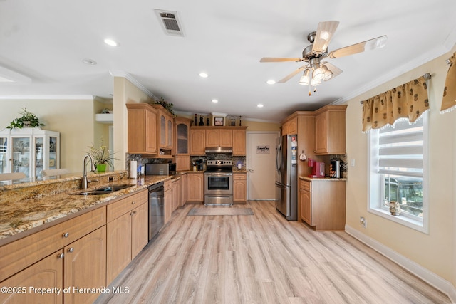 13027 Beacon Ct, Hudson, FL 34667 - kitchen with appliances with stainless steel finishes, crown molding, light stone counters, under cabinet range hood, and light wood finished floors