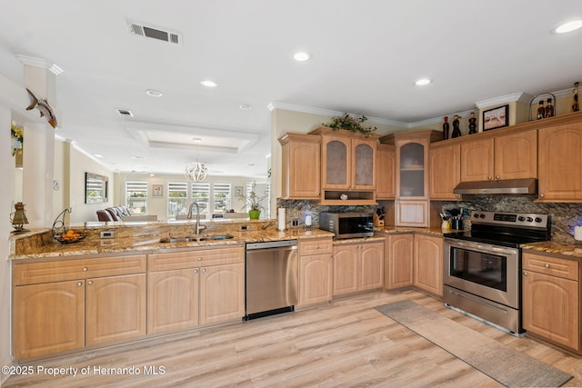 13027 Beacon Ct, Hudson, FL 34667 - kitchen featuring appliances with stainless steel finishes, under cabinet range hood, light wood-style floors, glass insert cabinets, and light stone counters