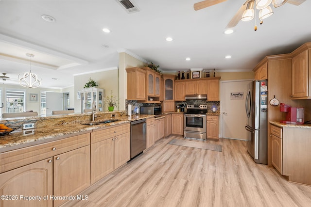 13027 Beacon Ct, Hudson, FL 34667 - kitchen featuring appliances with stainless steel finishes, ceiling fan, light stone countertops, ornamental molding, and glass insert cabinets