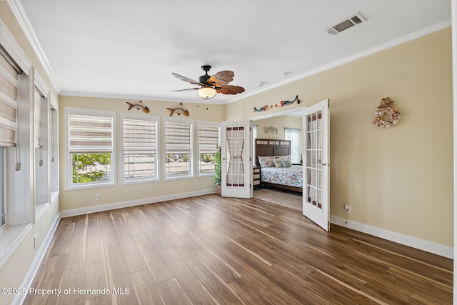 13027 Beacon Ct, Hudson, FL 34667 - unfurnished bedroom featuring french doors, wood finished floors, ornamental molding, and a ceiling fan