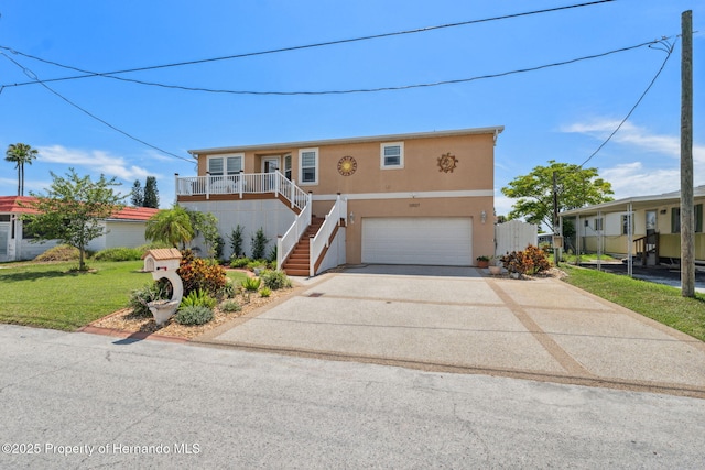 13027 Beacon Ct, Hudson, FL 34667 - view of front of home featuring stucco siding, an attached garage, concrete driveway, stairway, and a front yard