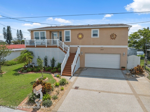 13027 Beacon Ct, Hudson, FL 34667 - view of front of home with a garage, stucco siding, concrete driveway, a front lawn, and stairs