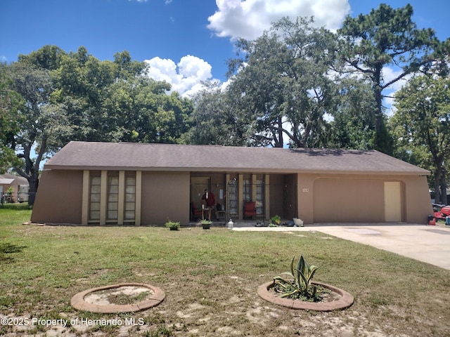 2419 Appian Ave, Spring Hill, FL 34608 - view of front of house featuring concrete driveway, a garage, a front lawn, and stucco siding