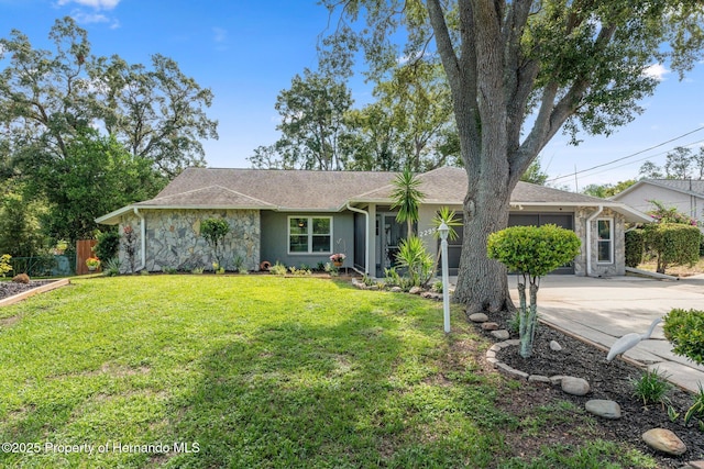 2295 Rio Cir, Spring Hill, FL 34608 - view of front of home featuring an attached garage, concrete driveway, and stone siding