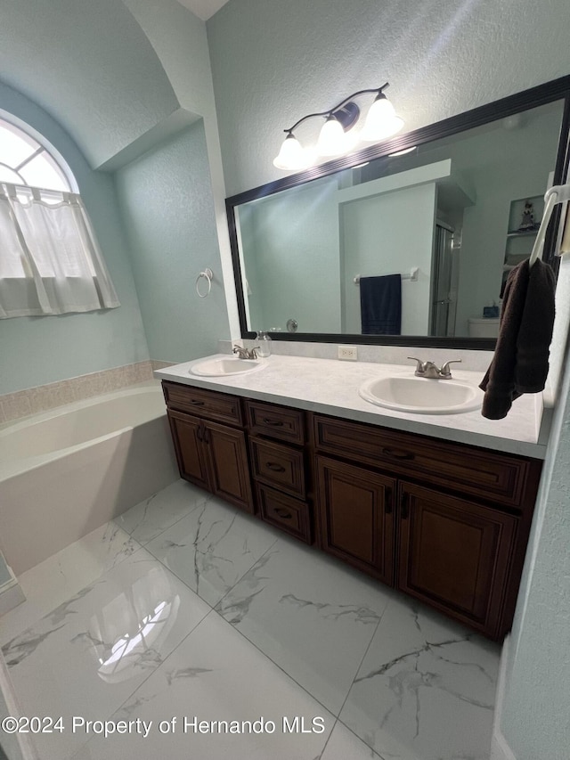 5388 Idleweise Ct, Spring Hill, FL 34606 - full bathroom with a bath, double vanity, a textured wall, marble finish floors, and a shower stall
