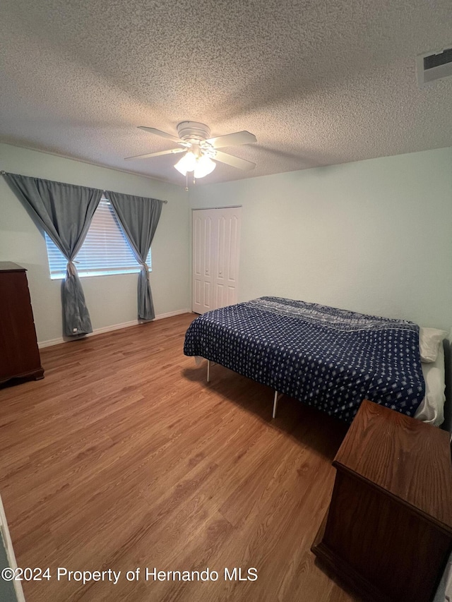 5388 Idleweise Ct, Spring Hill, FL 34606 - bedroom with wood finished floors, a closet, a textured ceiling, and a ceiling fan