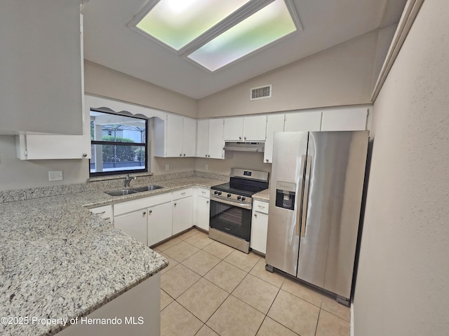 18232 Monteverde Dr, Spring Hill Pasco, FL 34610 - kitchen featuring stainless steel appliances, under cabinet range hood, lofted ceiling, light tile patterned floors, and white cabinetry