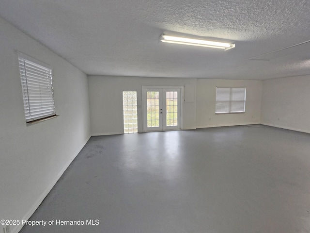 18232 Monteverde Dr, Spring Hill Pasco, FL 34610 - empty room featuring a textured ceiling, french doors, and finished concrete flooring
