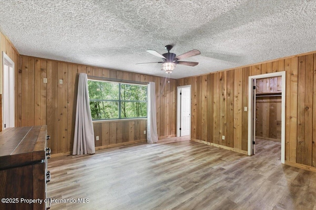 1518 Palm St, Steinhatchee, FL 32359 - unfurnished bedroom featuring wood finished floors, wood walls, ceiling fan, and a textured ceiling