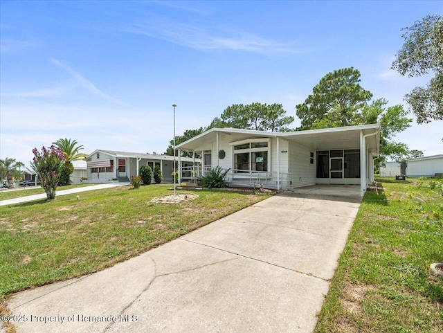 8017 Fiat Ave, Brooksville, FL 34613 - manufactured / mobile home with a front lawn, driveway, and a carport