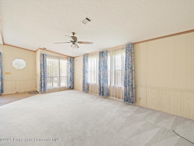 8017 Fiat Ave, Brooksville, FL 34613 - carpeted empty room with a ceiling fan, ornamental molding, a textured ceiling, and wooden walls