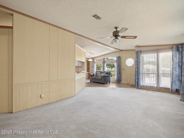 8017 Fiat Ave, Brooksville, FL 34613 - unfurnished living room with a textured ceiling, ceiling fan, ornamental molding, carpet, and vaulted ceiling