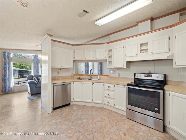 8017 Fiat Ave, Brooksville, FL 34613 - kitchen featuring appliances with stainless steel finishes, a textured ceiling, vaulted ceiling, light countertops, and under cabinet range hood