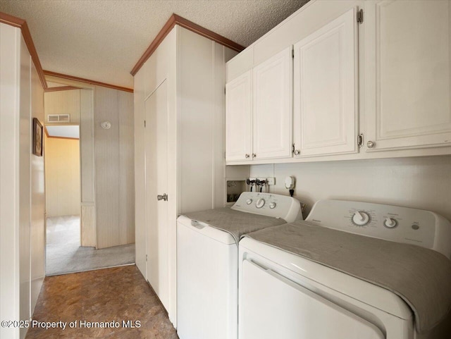 8017 Fiat Ave, Brooksville, FL 34613 - laundry room with washing machine and clothes dryer, cabinet space, a textured ceiling, and ornamental molding