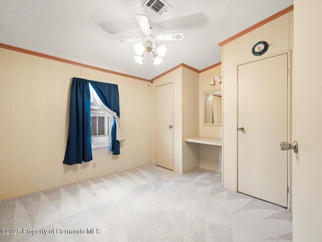 8017 Fiat Ave, Brooksville, FL 34613 - unfurnished bedroom with carpet flooring, ornamental molding, a ceiling fan, a textured ceiling, and an office area