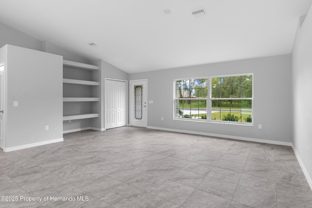 12128 Petrel Ave, Brooksville, FL 34614 - unfurnished living room featuring built in shelves and lofted ceiling
