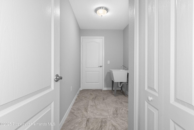 12128 Petrel Ave, Brooksville, FL 34614 - laundry room with baseboards and a sink