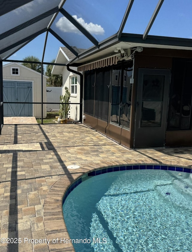 4385 7th Isle Dr, Hernando Beach, FL 34607 - view of swimming pool with a patio area, a storage shed, a sunroom, and a lanai