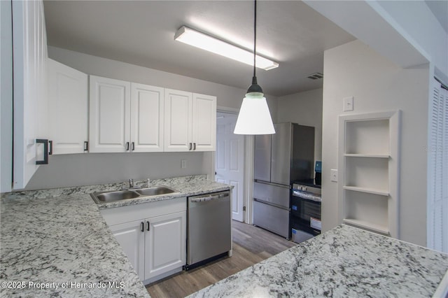 9345 N Elliot Way, Citrus Springs, FL 34434 - kitchen featuring stainless steel appliances, light wood-style flooring, white cabinets, hanging light fixtures, and light stone counters