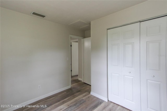 9345 N Elliot Way, Citrus Springs, FL 34434 - unfurnished bedroom featuring attic access, wood finished floors, and a closet