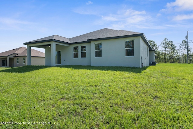 16113 Penn State Rd, Weeki Wachee, FL 34614 - back of house featuring stucco siding, a lawn, and roof with shingles