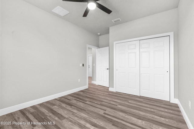 16113 Penn State Rd, Weeki Wachee, FL 34614 - unfurnished bedroom with wood finished floors, a closet, and ceiling fan